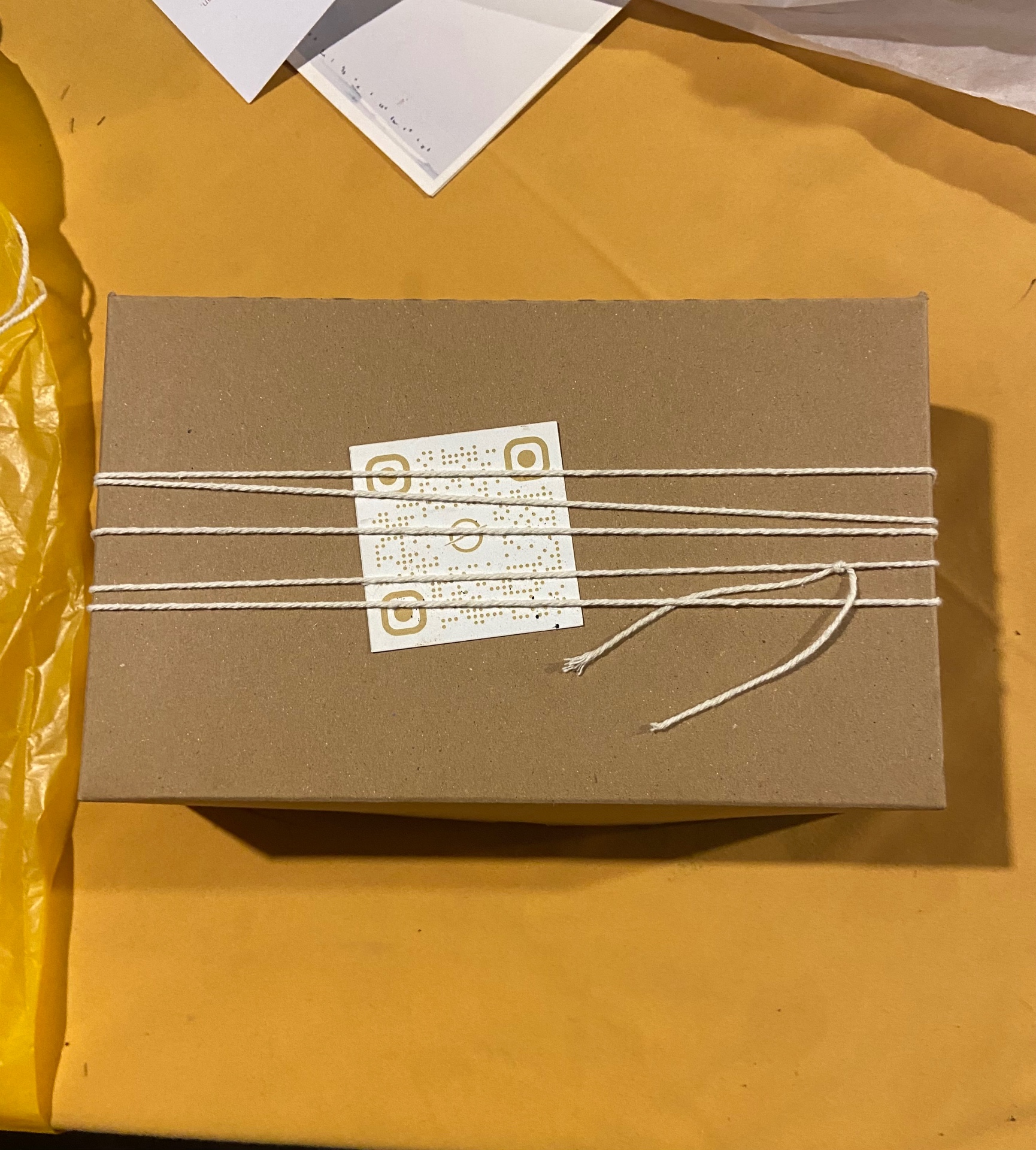 A SOICHU parcel wrapped in kraft paper and cotton twine with a QR code seal