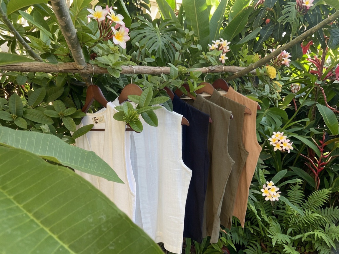 SOICHU vests hanging on a branch surrounded by plumeria flowers in Bali
